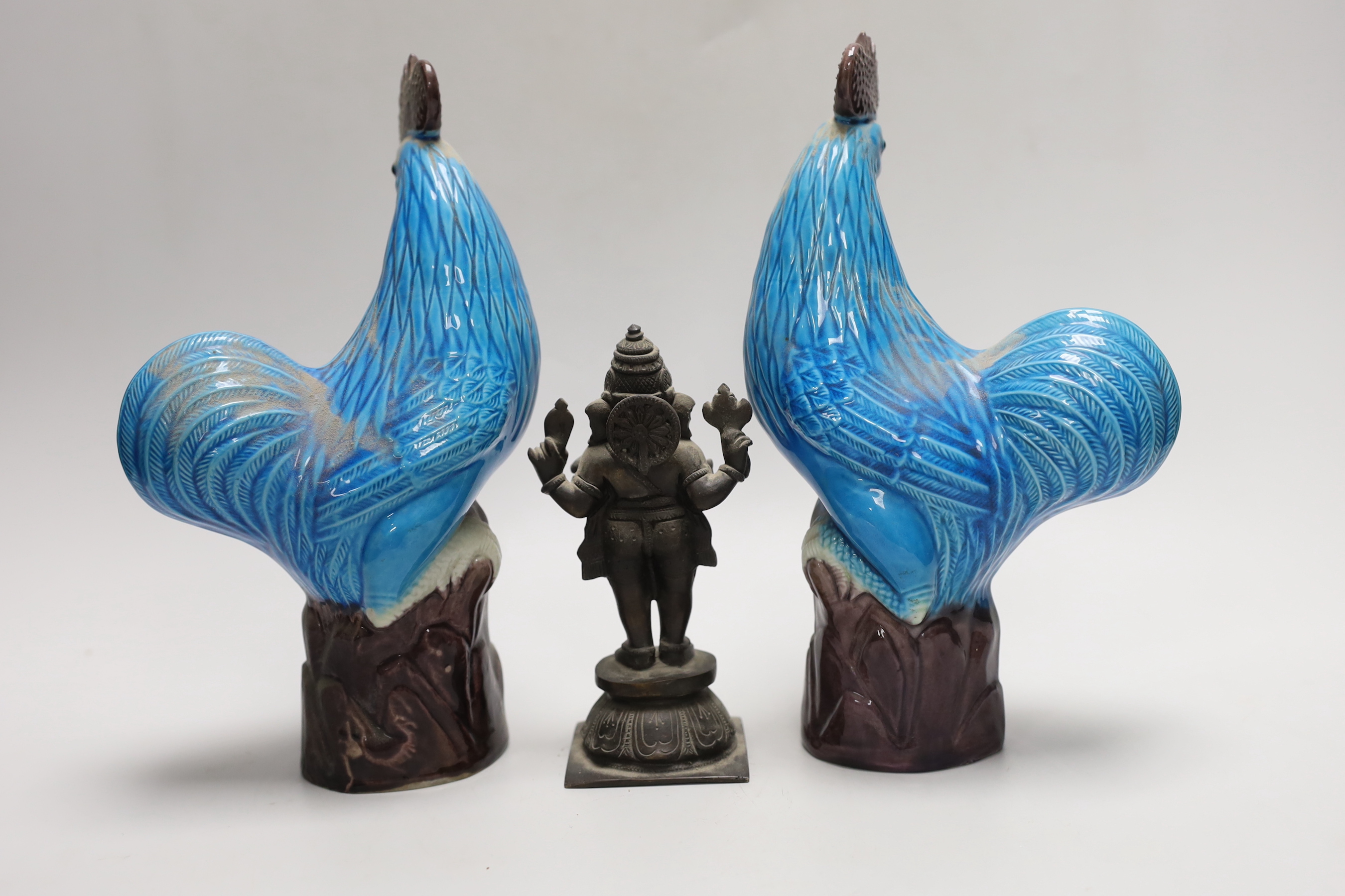 A pair of Chinese export polychrome models of cockerels, 25cm, and a small export cast bronze figure of Ganesh (3)